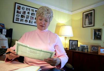 Helen Walker holds the deed to four cemetery plots in Maryland that she is trying to sell as she works in her home office in Indian Trail, N.C.  (Associated Press / The Spokesman-Review)