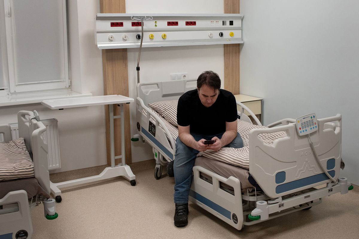 Kyle Varner sits on his bed for the night at the Lviv Clinical Municipal Hospital on March 10, 2022. Varner, a doctor at Holy Family Hospital in Spokane will spend roughly the next month in Lviv, a Ukrainian city about 43 miles from the Polish border.  (Eli Francovich/The Spokesman-Review)