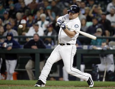 Seattle’s Adam Lind swings for a grand slam against the Texas Rangers in the first inning  Wednesday. (Elaine Thompson / Associated Press)
