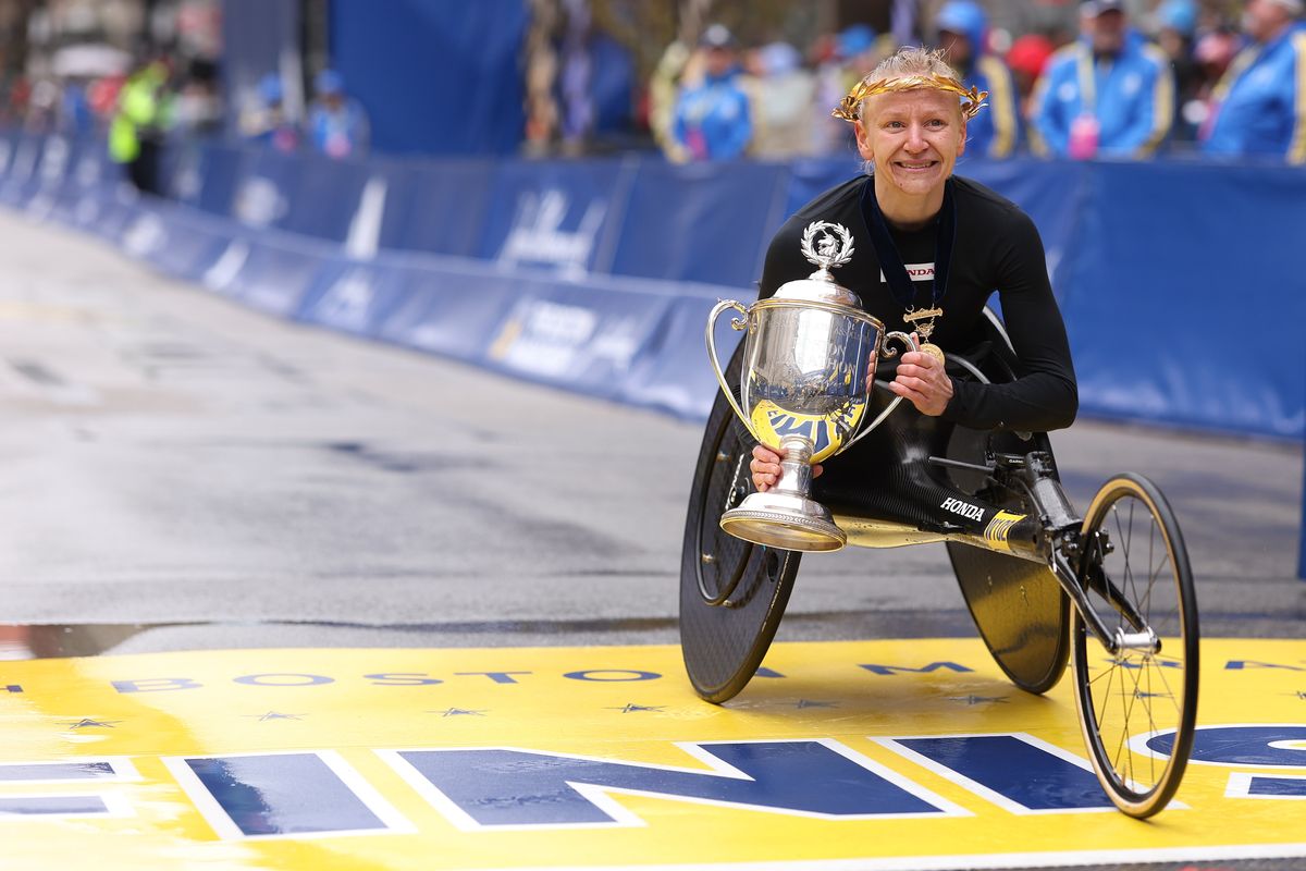 Susannah Scaroni of Tekoa celebrates with the trophy on the finish line on Monday after winning the professional Women