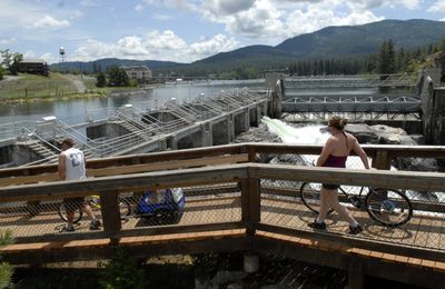 Cyclists scope  the North Channel Dam at Falls Park on the Spokane River, part of the Post Falls Dam. The park is in line for a facelift. (J. BART RAYNIAK / The Spokesman-Review)