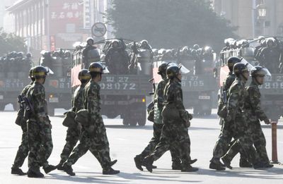 Paramilitary police officers make their way through the street of central Urumqi, China, today. Associated Press photo/Kyodo News (Associated Press photo/Kyodo News / The Spokesman-Review)