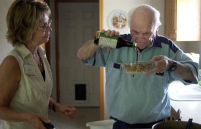 
Nutrition counselor Pam Wright watches as Joe Herbert Sr. adds soy sauce to the stir fry she taught him to make. 
 (Liz Kishimoto / The Spokesman-Review)