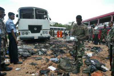 
A Sri Lankan soldier inspects the debris at the site of a suicide explosion that killed 93 sailors near Dambulla, Sri Lanka, Monday. 
 (Associated Press / The Spokesman-Review)