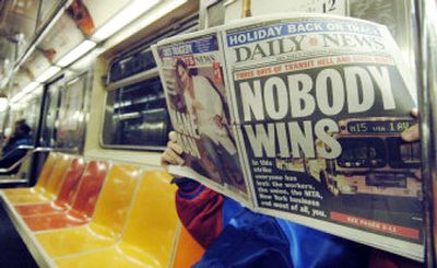 
A commuter on a Manhattan-bound train reads the New York Daily News, featuring a headline about the end of New York's three-day transit strike Friday. 
 (Associated Press / The Spokesman-Review)