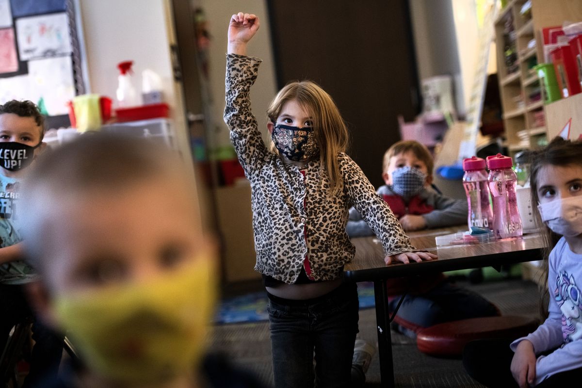 Winton Elementary kindergartner Araya Morgan wears a mask as she raises her hand during class on Thursday.  (Kathy Plonka/The Spokesman-Review)
