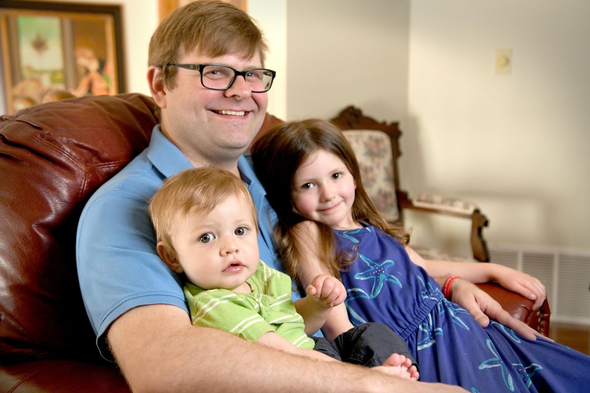 Spokane Symphony principal bassist Patrick McNally, shown at home with his children, Oliver and Alice on May 22, suffered a stroke in 2017 and fought to get back to playing bass. (Jesse Tinsley / The Spokesman-Review)