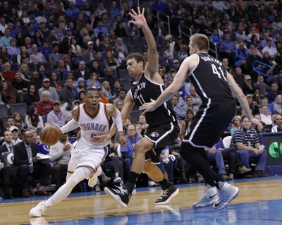 Oklahoma City Thunder guard Russell Westbrook drives to the basket around Brooklyn Nets center Brook Lopez during the second half of Friday’s game in Oklahoma City. (Alonzo Adams / Associated Press)