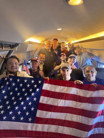 In a photo released on social media by the Office of the Special Presidential Envoy for Hostage Affairs, some of the 10 freed Americans who had been detained in Venezuela as they returned to the U.S. on July 18, 2025. Dahud Hanid Ortiz is at center right, holding a small flag. Ortiz killed three people, according to court documents.    (Office of the Special Presidential Envoy for Hostage Affairs via The New York Times)