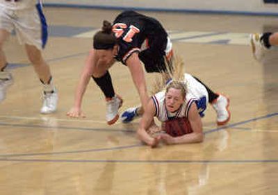 
Coeur d'Alene Viking Jackie Lenz, right, smothers the basketball after stealing it from Post Falls Trojan Mackenzie Sinclair Friday in Coeur d'Alene. Coeur d'Alene ran away with the game 72-31.
 (Tom Davenport/ / The Spokesman-Review)