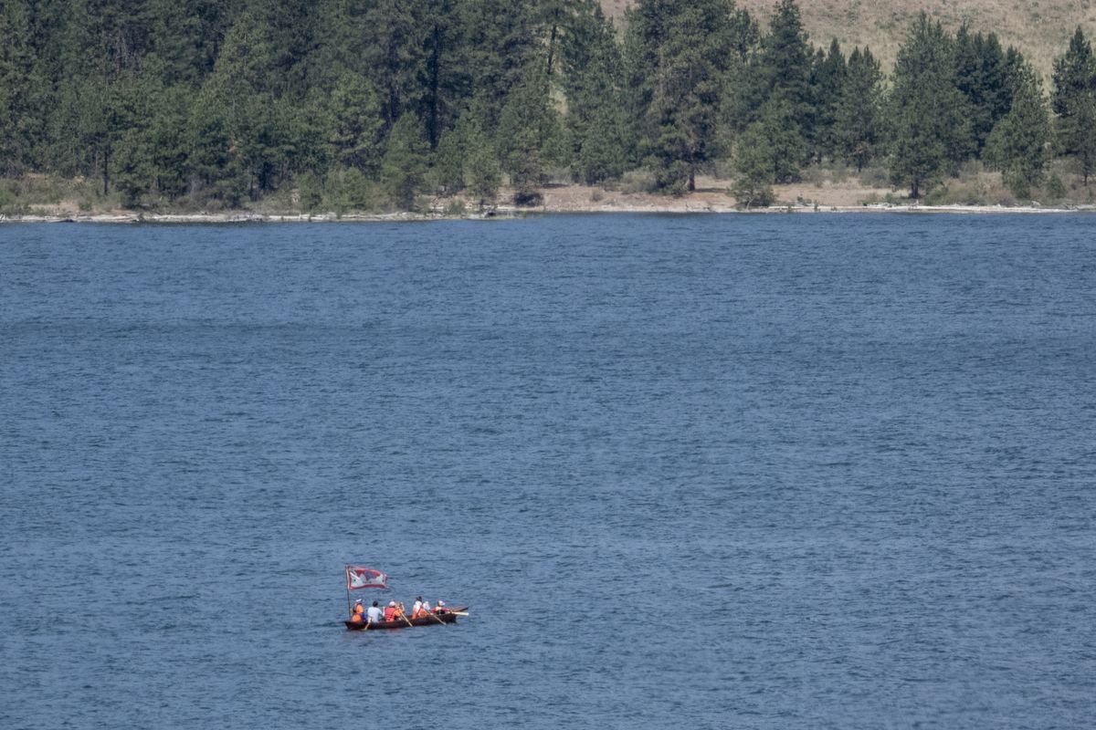 A traditional cedar canoe heads up the Columbia River from the Two Rivers area at the confluence of the Spokane and Columbia Rivers Tuesday, June 15, 2021. It was a trip by Native youth to learn about their tribes’ history in the area while on a four-hour paddle up the Columbia. They met at nearby Fort Spokane, a military post founded in 1880, but it was also a school to educate Native kids, a process which was not always voluntary.  (Jesse Tinsley/The Spokesman-Review)