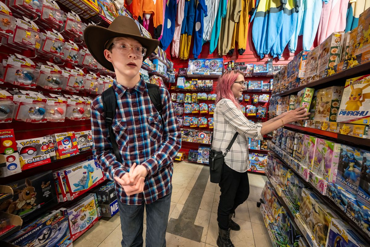 Elaina Nixon, right, a volunteer peer mentor with the TREK program and client Jackson VanHeel, 13, browse the shelves of the Comic Book Shop at NorthTown Mall on July 13.  (COLIN MULVANY/THE SPOKESMAN-REVIEW)