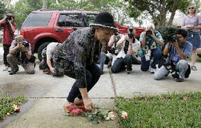 
A large group of photographers document a protester placing a rose on the sidewalk outside Michael Schiavo's house Sunday afternoon. 
 (Associated Press / The Spokesman-Review)