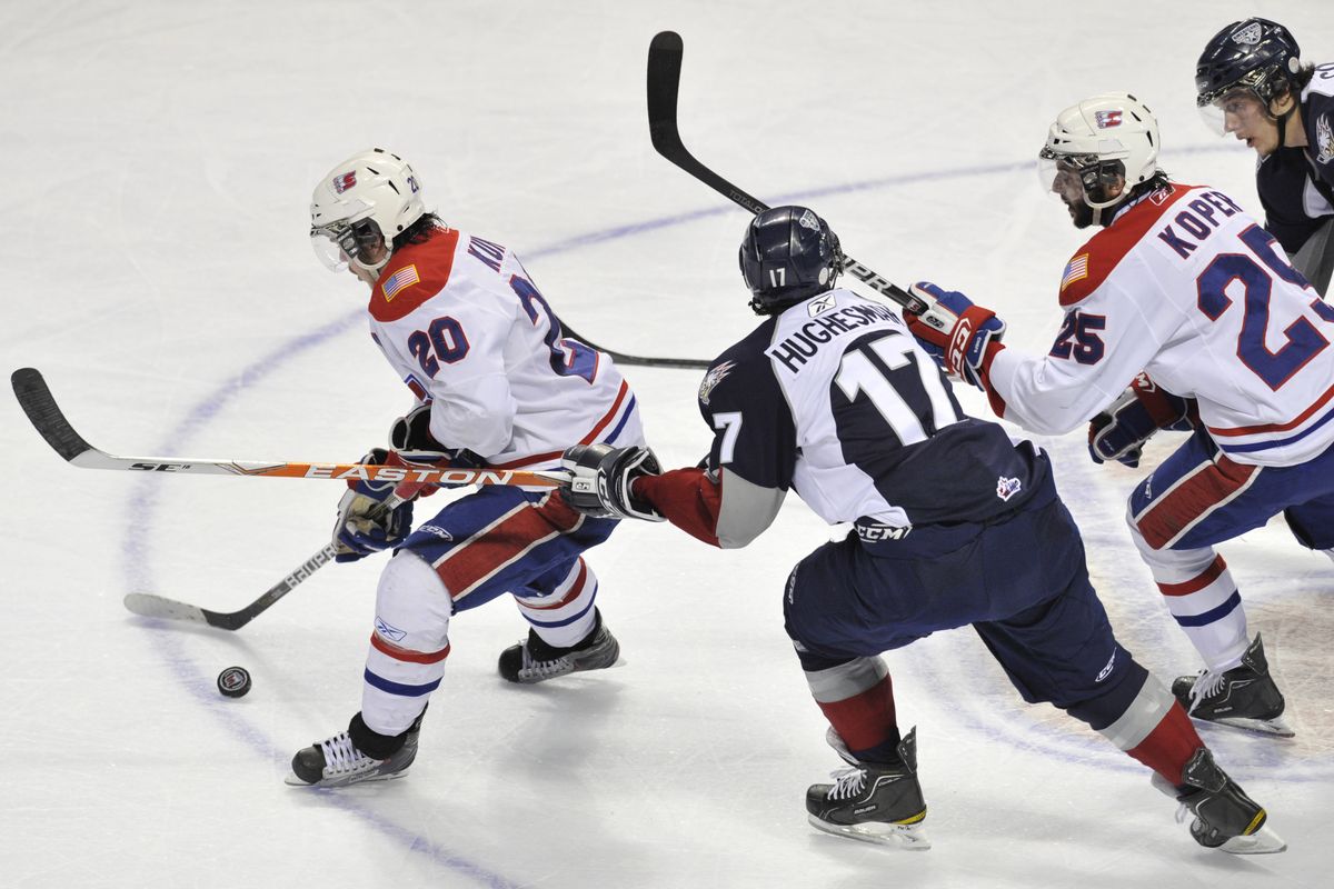 In the second period, Spokane Chiefs Steven Kuhn (20)  gets the puck out in front of  Tri-City Americans Adam Hughesman  (17) in game 6 of their WHL playoff game Tuesday, April 19, 2011 in the Spokane Arena. (Colin Mulvany / The Spokesman-Review)