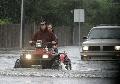 A couple make their way down John Rodes Boulevard on an all-terrain vehicle in Melbourne, Fla., on Wednesday.  (Associated Press / The Spokesman-Review)