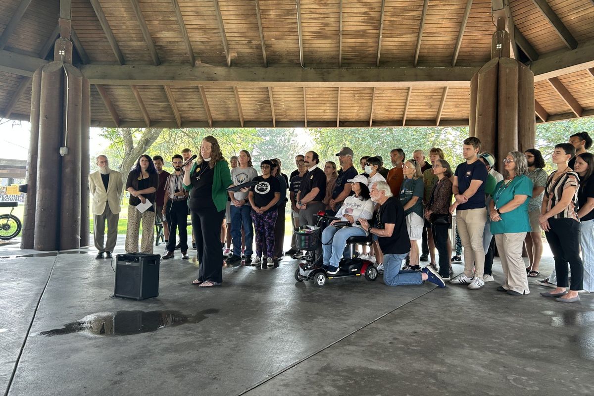 Pastor Emily Kuenker speaks to a gathered crowd underneath a shelter next to the Ice Age Floods Playground in Riverfront Park on Wednesday, Sept. 10, 2025, in Spokane, Wash.   (Mathew Callaghan/The Spokesman-Review)