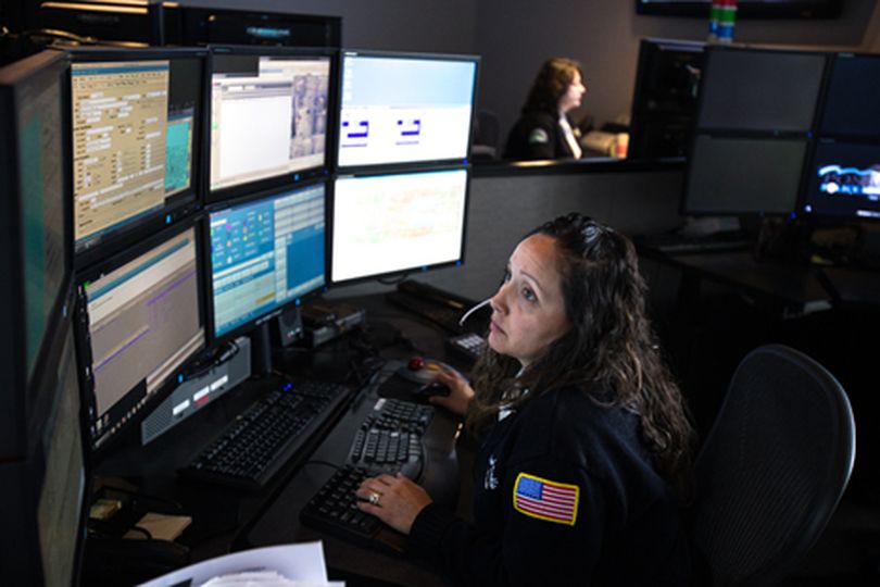 Emergency call operator for the Post Falls police department works at her station Wednesday. Post Falls police will be sending out live feeds over Facebook and Twitter Friday night during what they are calling a ���Tweet Along��� in order to give the public a glimpse into the typical night of an officer. (Gabe Green/press)