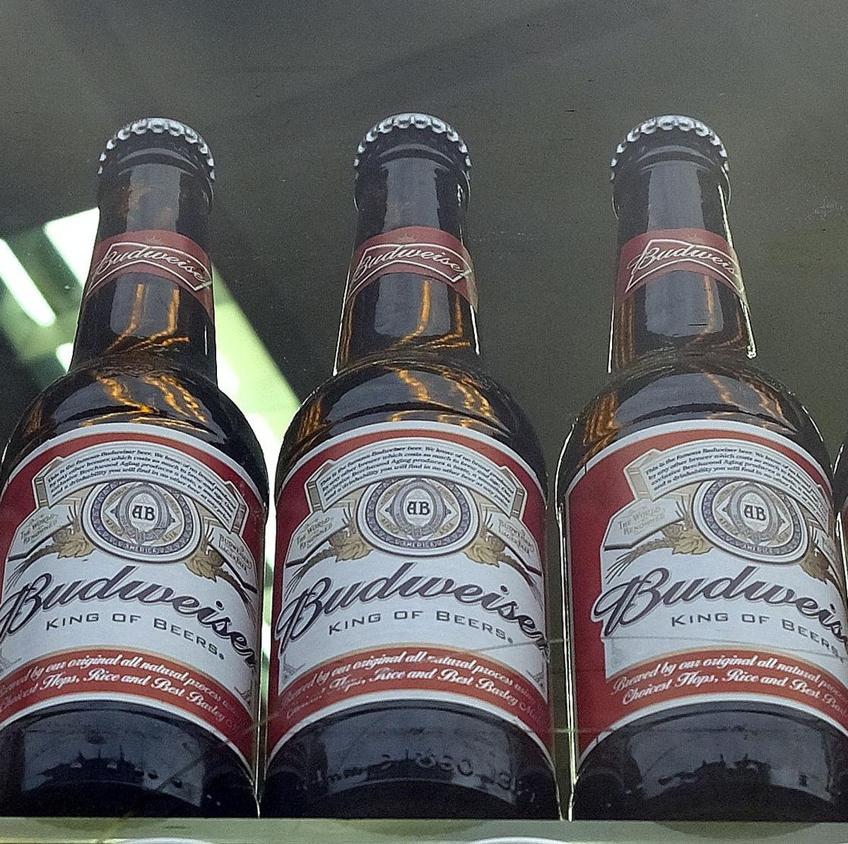 Bottles of Budweiser beer in a shop window in London on Tuesday. The world's top two beer makers agreed Tuesday to join forces to create a company that would control nearly a third of the global market. AB InBev's brands include Budweiser, Stella Artois and Corona, while SABMiller produces Peroni and Grolsch. (Kirsty Wigglesworth / Associated Press)