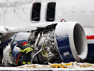 A firefighter investigates the damaged right engine Sunday.  (Associated Press / The Spokesman-Review)