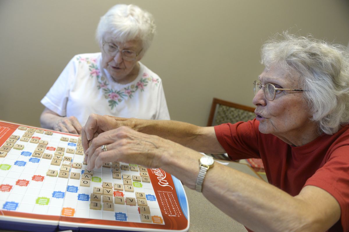 Midge Thorin, right, makes a play while Jan Cheslog contemplates her options Aug. 27 at Centerplace in Spokane Valley. The Scrabble enthusiasts play every Wednesday. (Jesse Tinsley)