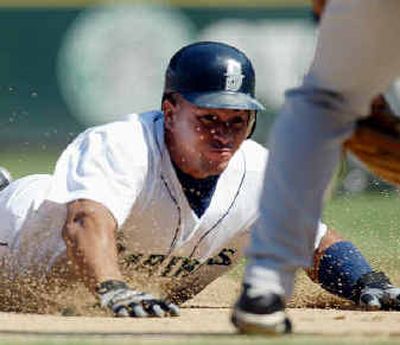 
Seattle's Miguel Olivo slides into third.
 (Associated Press / The Spokesman-Review)