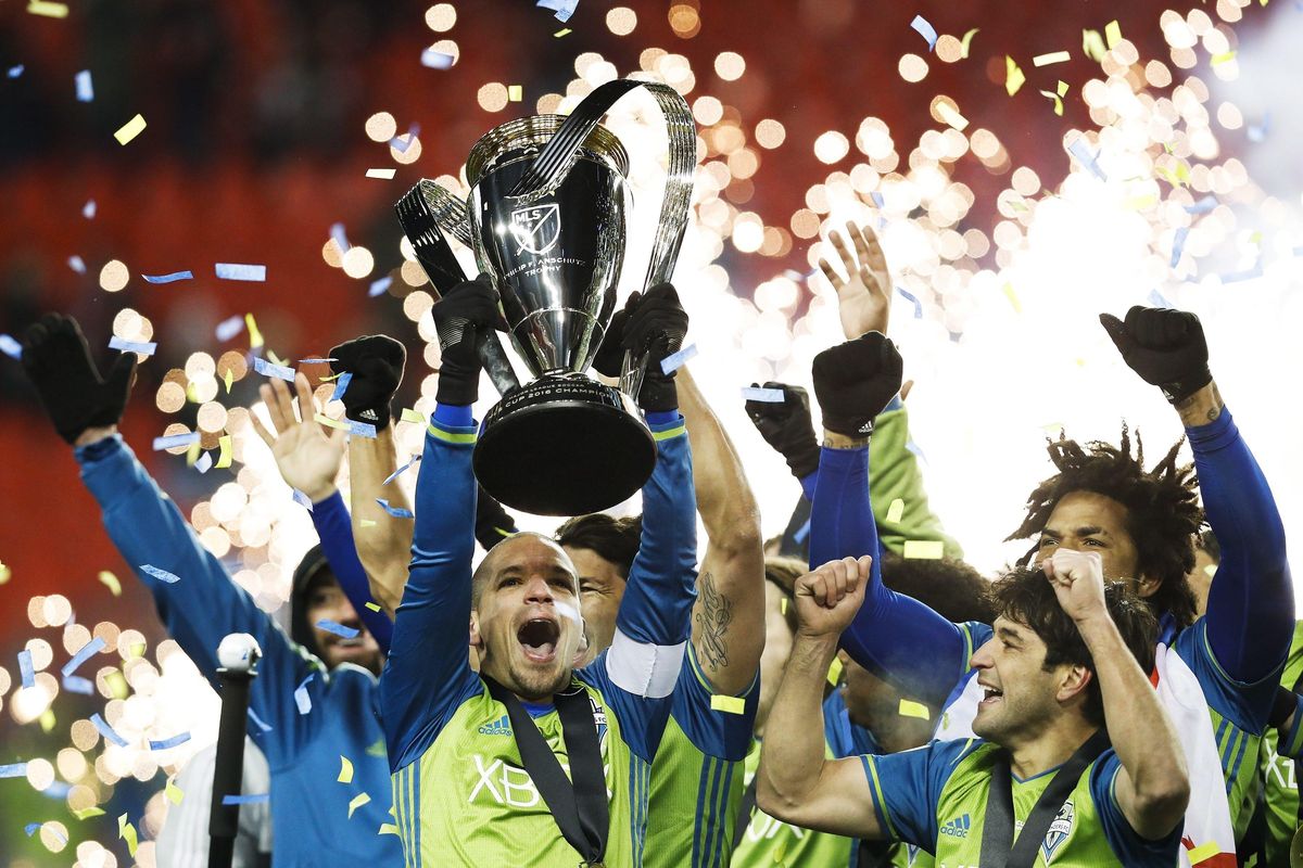 Seattle Sounders midfielder Osvaldo Alonso, front left, hoists soccer’s MLS Cup with teammates after defeating Toronto FC, Saturday, Dec. 10, 2016 in Toronto. (Mark Blinch / Canadian Press via AP)