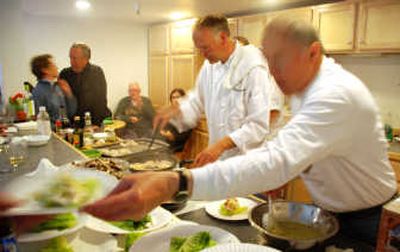 
Seattle restaurant owner and chef Ludger Szmania, center, serves anglers samples of his gourmet fish recipes after the group returned from a day of fishing with Angling Unlimited.
 (The Spokesman-Review)