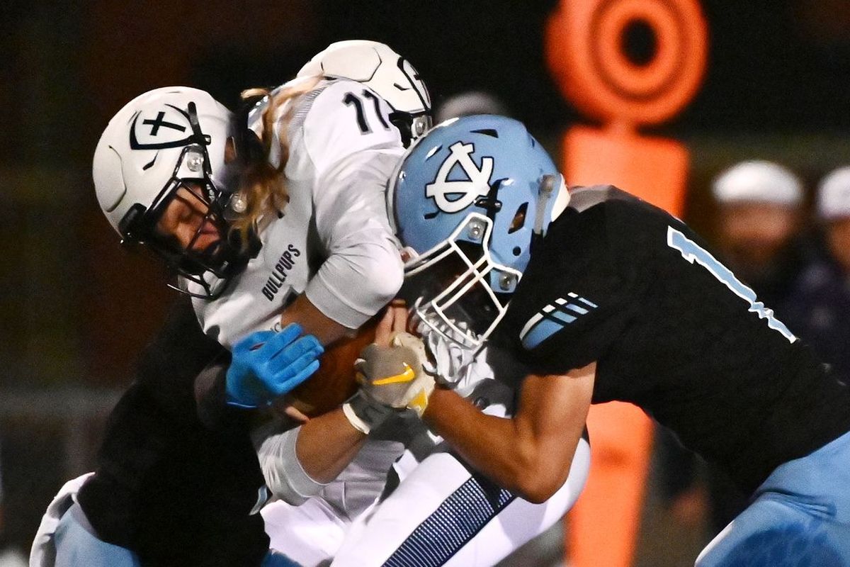 Central Valley’s Nic Saunders, right, tackles Gonzaga Prep quarterback Ryan McKenna after a first down in Friday’s Greater Spokane League game at CV.  (James Snook For The Spokesman-Review)