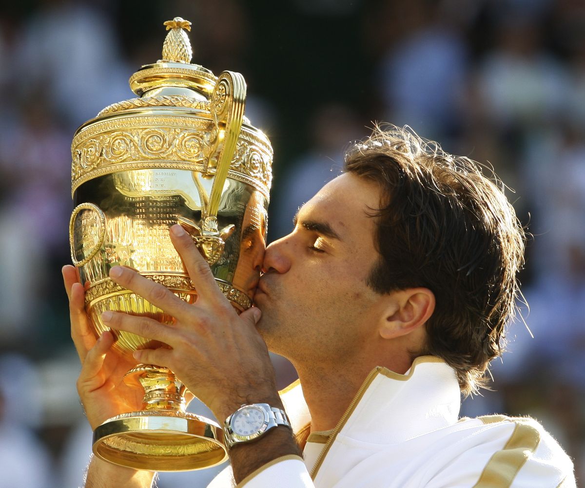 Roger Federer kisses the champion’s trophy after winning Wimbledon for the sixth time. (Associated Press / The Spokesman-Review)