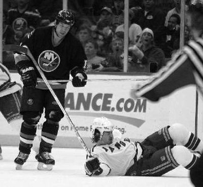 
Ryan Hollweg lands on ice after Chris Simon hit him in the face with his stick Thursday. 
 (Associated Press / The Spokesman-Review)