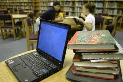 
An IBM ThinkPad computer, left, shown in a grade-school library. next to a stack of text. International Business Machines Corp. has reportedly put its personal computer business up for sale in a deal that could fetch as much as $2 billion and close an era for an industry pioneer that long ago shifted its focus to more lucrative areas.
 (Associated Press / The Spokesman-Review)