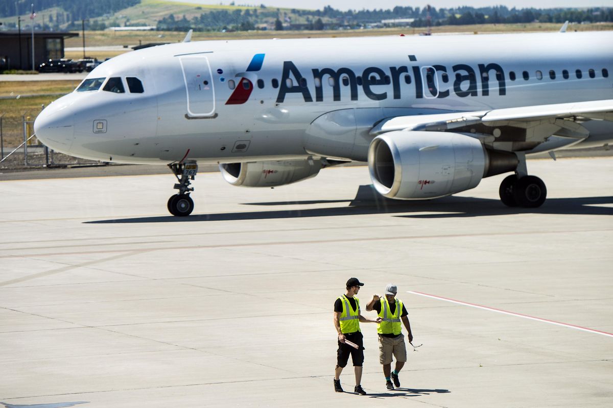 American Airlines ground crew members slap hands Wednesday, July 5, 2017, at Spokane International Airport, where the inaugural nonstop flight from Dallas-Fort Worth arrived earlier in the day. (Dan Pelle / The Spokesman-Review)