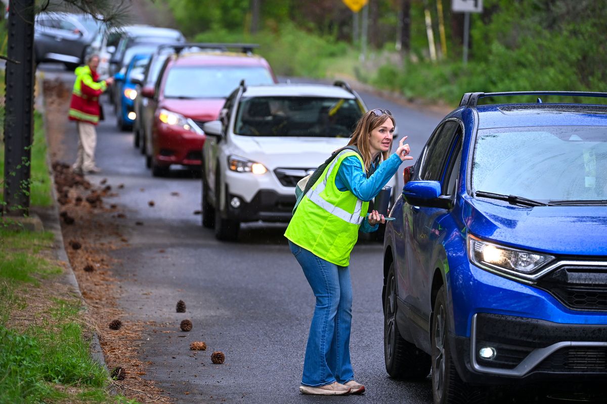 Volunteer observer Kate Telis guides motorists during a wildfire evacuation drill at the corner of Lindeke Street and 14th Avenue on Saturday. (DAN PELLE/FOR THESPOKESMN-REVIEW)