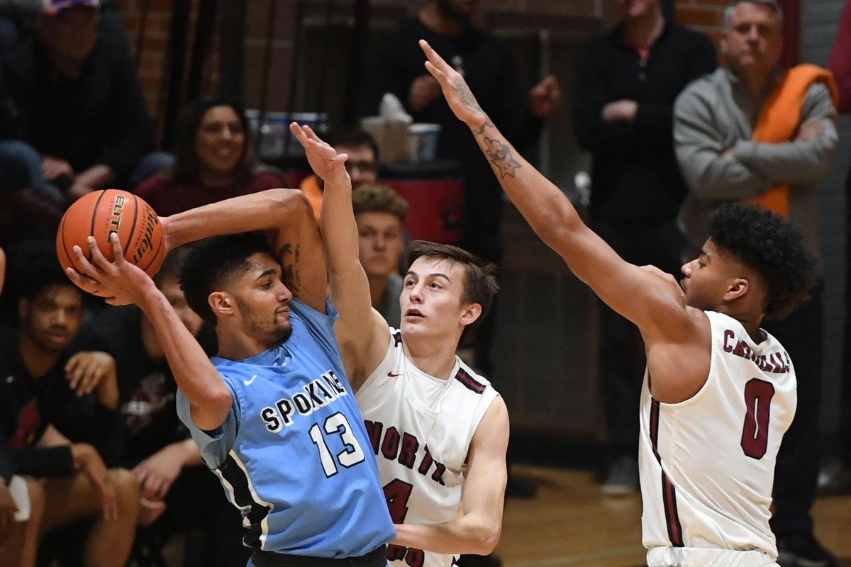 Community Colleges of Spokane guard Anthony Parker (13) looks to pass the ball as North Idaho College guard Phillip Malatare (4) and guard RayQuan Evans (0) defend during a college basketball game, Wed. Feb. 20, 2019, at NIC. (Colin Mulvany / The Spokesman-Review)