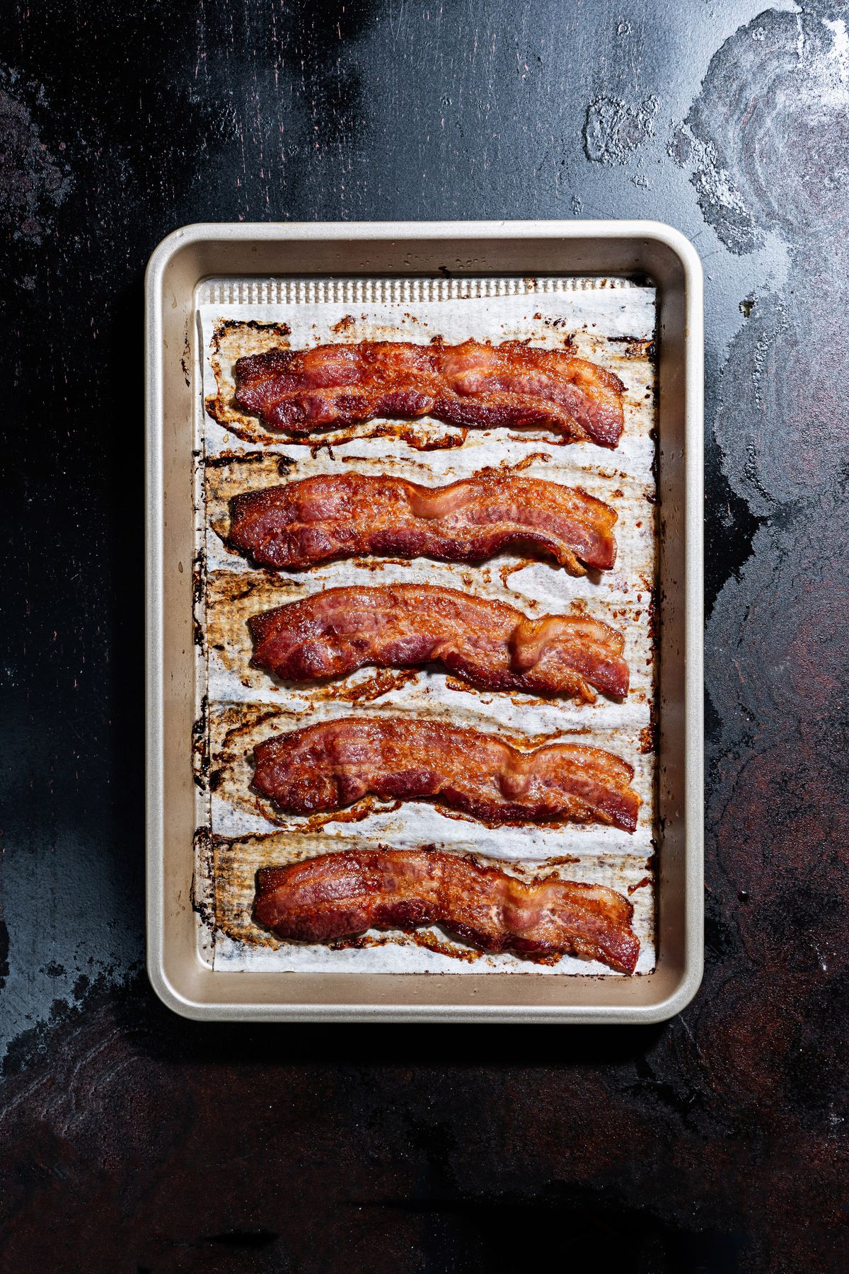 Bacon cooked in an oven on a sheet pan.  (Scott Suchman/For the Washington Post)