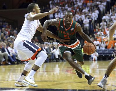 Miami guard Davon Reed, right, drives past Virginia guard Devon Hall during the first half of an NCAA college basketball game Monday, Feb. 20, 2017, in Charlottesville, Va. (Ryan M. Kelly / Associated Press)