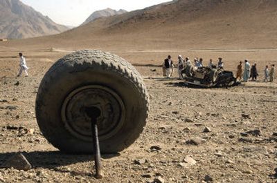 
A wheel rests some distance from an overturned vehicle after a bomb blast Saturday on the outskirts of Kabul, Afghanistan. 
 (Associated Press / The Spokesman-Review)