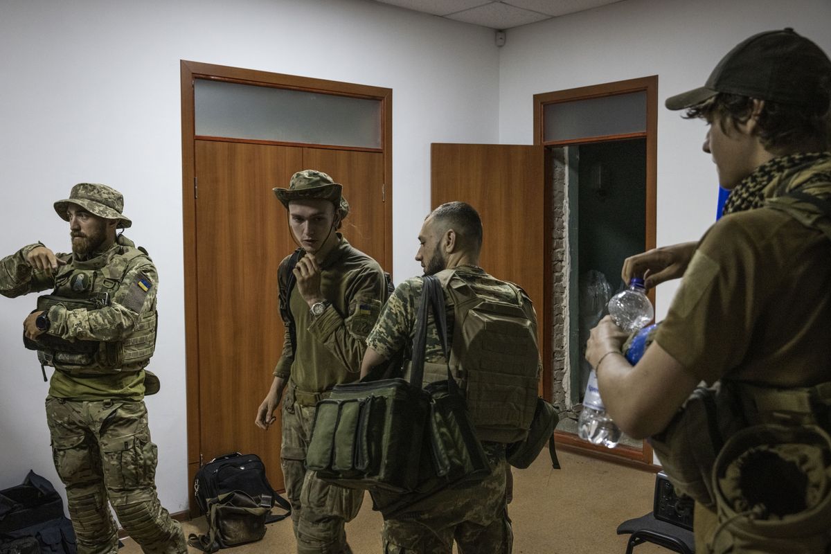 Soldiers with the call signs Labrador, left, Witcher, 19, center left, Chuck, center right, and Miami get ready on a base in Zaporizhzhia, Ukraine, to go to the front line before dawn in July. The Washington Post spent the night and morning with a unit from Ukraine