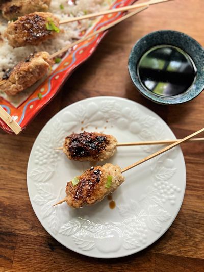 Chicken skewers with a salty-sweet sauce are simmered in water before being glazed on the grill.  (Gretchen McKay)