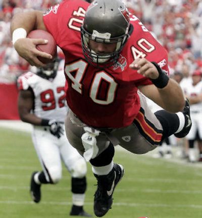 
Tampa Bay Buccaneers fullback Mike Alstott leaps over the Atlanta Falcons' defense to score on a 13-yard, second-quarter touchdown pass from Chris Simms, with Atlanta's Chauncey Davis (92) chasing the play. 
 (Associated Press / The Spokesman-Review)