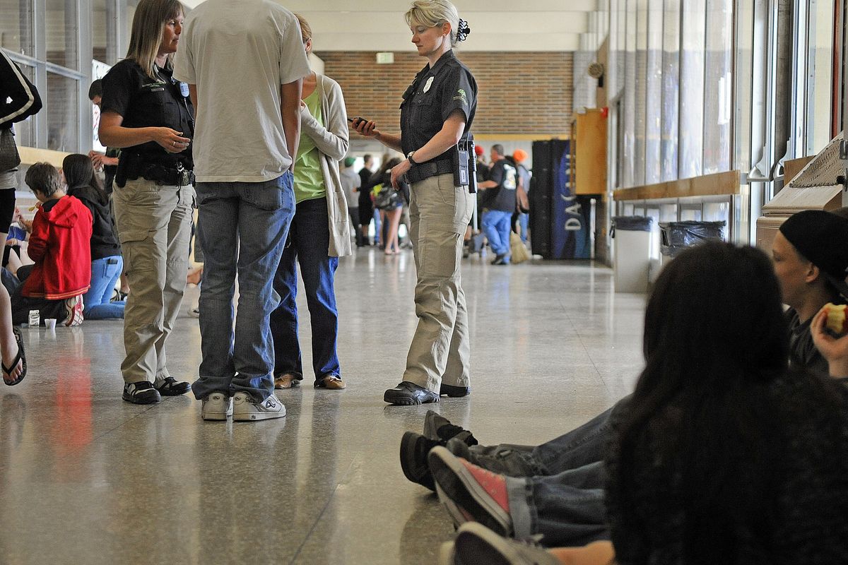 Spokane Public Schools Resource Officers Satanya Haws, left, and Becky Wilkey, right, interact with a group of students outside the lunchroom on the Ferris High School campus on June 15. (Christopher Anderson)