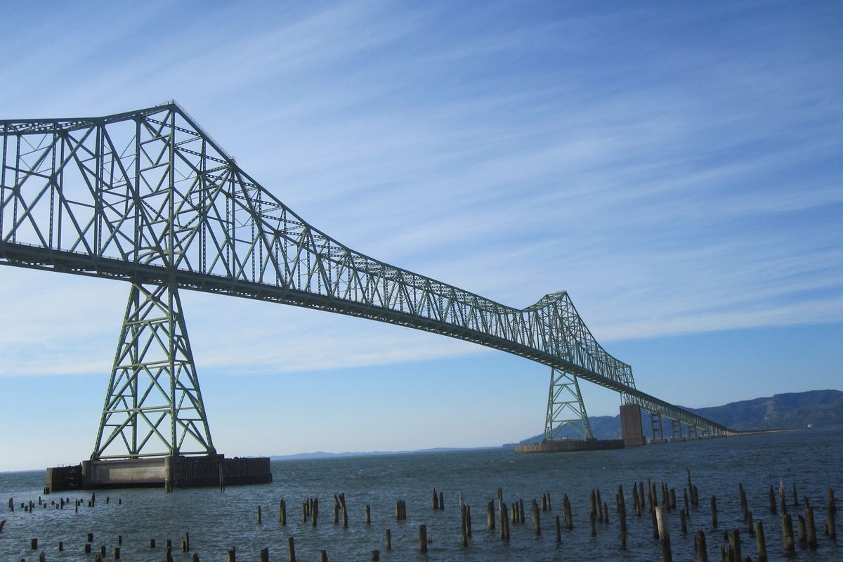 The Astoria-Megler Bridge spans the Columbia River, connecting Oregon and Washington. The pilings in the foreground provide evidence of the numerous canneries that at one time made Astoria famous worldwide for Columbia River salmon.