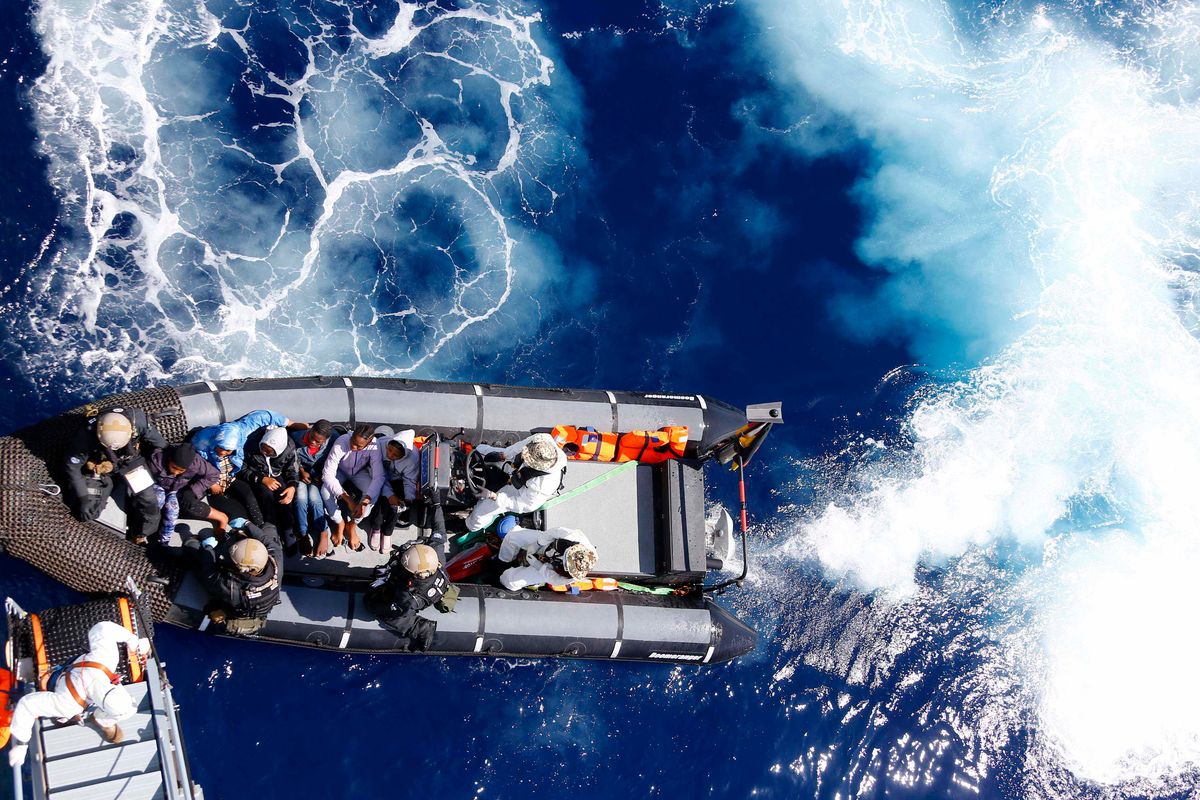 FILE - Rescued migrants sit in a German Navy boat besides Finish Special Forces prior to board the German combat supply ship "Frankfurt am Main" during EUNAVFOR MED Operation Sophia in the Mediterranean Sea off the coast of Libya on March 29, 2016. A confidential European Union military report calls for the continued support and training of Libya’s coastguard and navy despite concerns about their treatment of migrants, a mounting death toll at sea, and the continued lack of any central authority in the North African nation. The report circulated to EU officials on Jan. 4 and obtained by The Associated Press offers a rare insight into Europe’s determination to cooperate with Libya and its role in the interception and return of thousands of men, women and children to a country where they face insufferable abuse.  (Matthias Schrader)