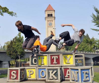 Nicholas Murray, Jarrod Swanson and Joey Penchoen perform tricks on the block sculpture in Riverfront Park on Monday. The three love the sport called “parkour,” running and performing tricks on obstacles and architectural features. (Jesse Tinsley)