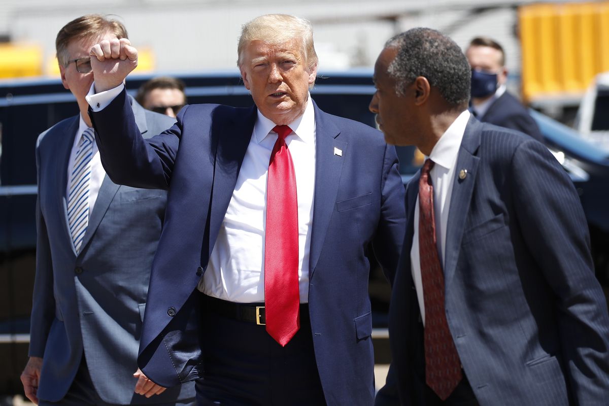 President Donald Trump walks with Texas Lt. Gov. Dan Patrick, left, and Housing and Urban Development Secretary Ben Carson as he arrives on Air Force One at Dallas Love Field, Thursday, June 11, 2020, in Dallas.  (Alex Brandon)