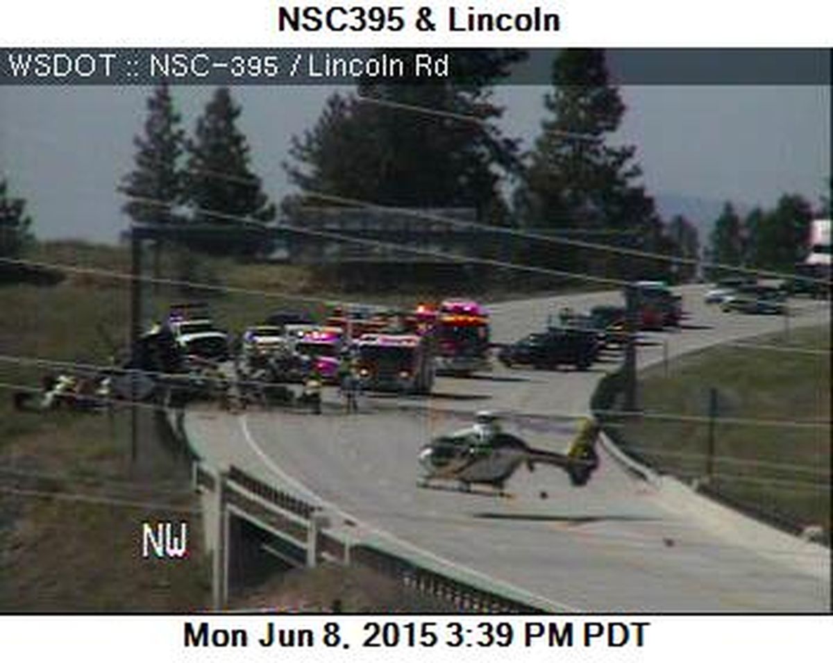 A Washington State traffic camera photo from Monday afternoon shows MedStar landing on the North Spokane Corridor to transport the driver of a semi trailer that rolled over. (Washington Department of Transportation)