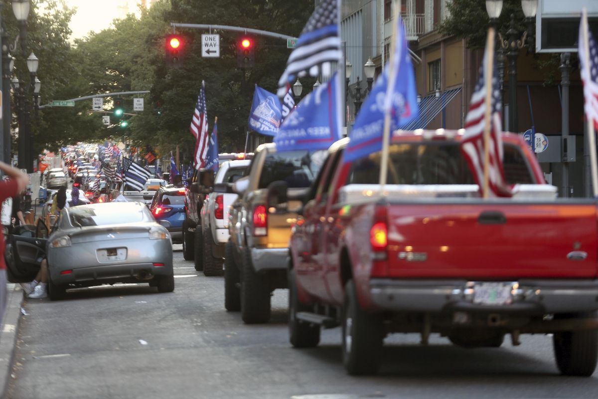 A caravan of supporters of President Donald Trump drive in downtown Portland, Ore., Saturday, Aug. 29, 2020. Saturday