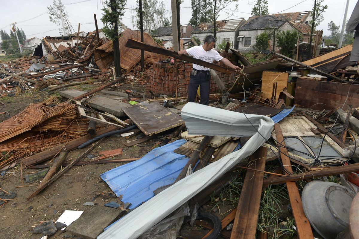 A man moves wood debris from a damaged structure in Funing county in Yancheng city in eastern China’s Jiangsu Province Friday, June 24, 2016. (AP)
