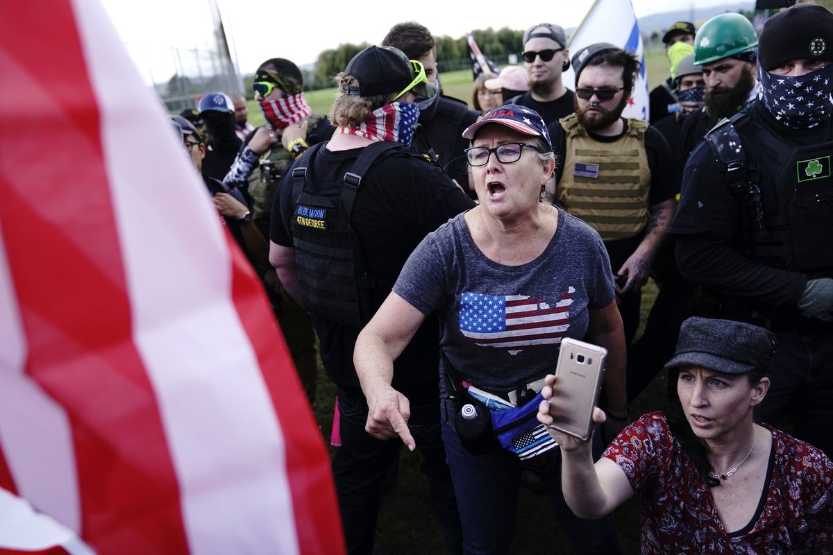 FILE – In this Sept. 26, 2020, file photo, a right-wing demonstrator, center, yells at a counter protester to leave a rally by members of the Proud Boys and other right-wing demonstrators in Portland, Ore. Alex DiBranco, executive director of the Institute for Research on Male Supremacism, said there are differences among Proud Boys chapters over whether to embrace women as Proud Girls or not, even as the group as a whole has become more hostile to women’s auxiliaries over the past couple of years.  (John Locher)