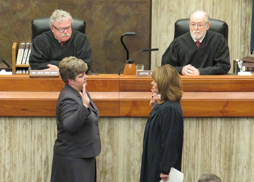 New Idaho Supreme Court Justice Robyn Brody, left, is sworn in Thursday by retired Chief Justice Linda Copple Trout, right; behind are new Chief Justice Roger Burdick, left, and Justice Warren Jones. (Betsy Z. Russell)